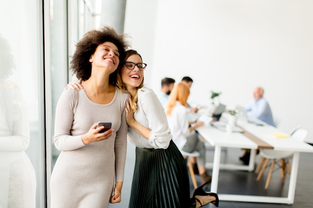 Pretty young women with moble phone in the office