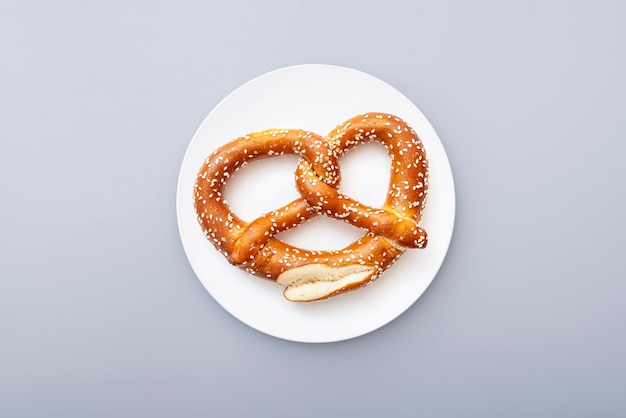 Pretzel als Oktoberfest-symbool op witte keramische plaat, bovenaanzicht