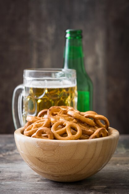 Pretzels in bowl and beer on wooden table