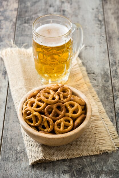 Pretzels in bowl and beer on wooden table