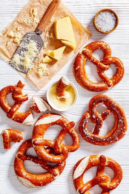 Photo pretzels in the form of knot with cheese sauce