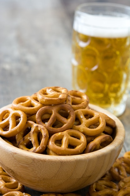 Pretzels in kom en bier op houten tafel