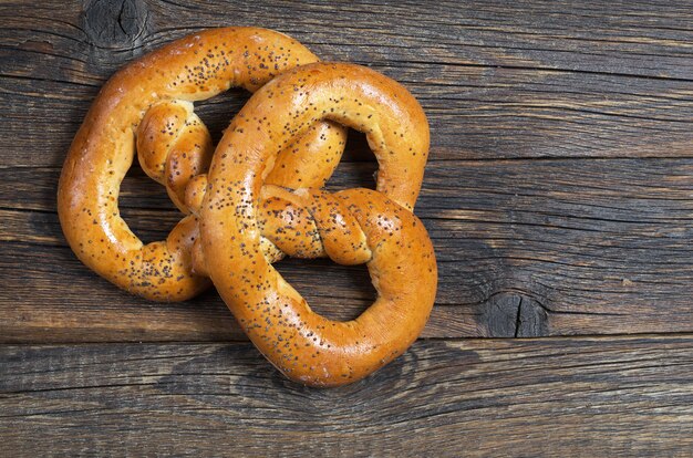 Pretzels with poppy seeds on wooden background, top view