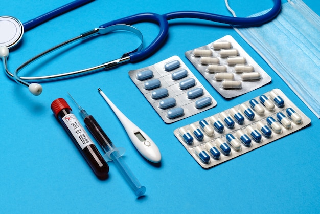 Preventie en behandeling van coronavirusgezondheidszorgconcept - spuit, masker, tabletten, stethoscoop en