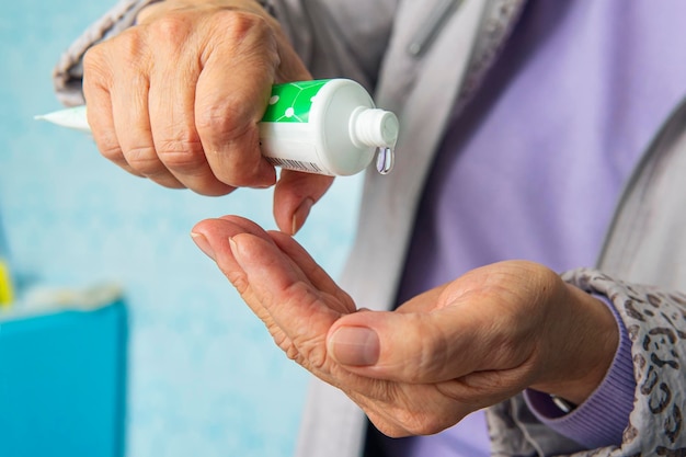 Preventing the spread of germs by using hand washing gel in elderly. To prevent the infection from a dangerous coronavirus. protection from covid-19, prevention of diseases, hand Sanitization.