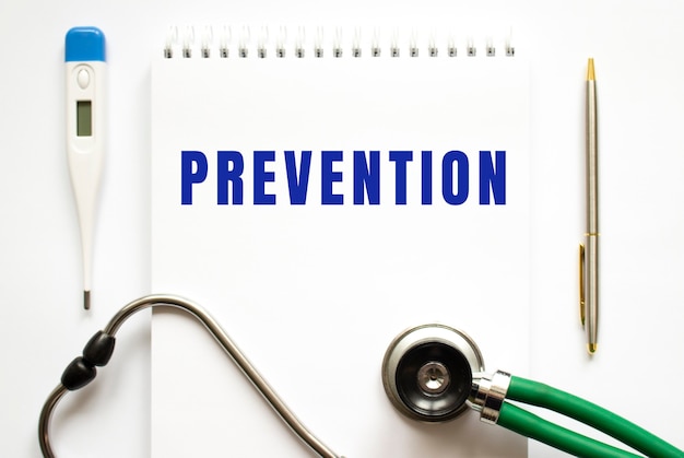 Photo prevention text written in a notebook lying on a desk and a stethoscope