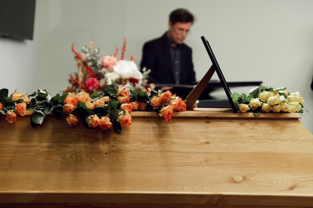 Photo the priest conducts the funeral service hard times funeral service coffin with flowers