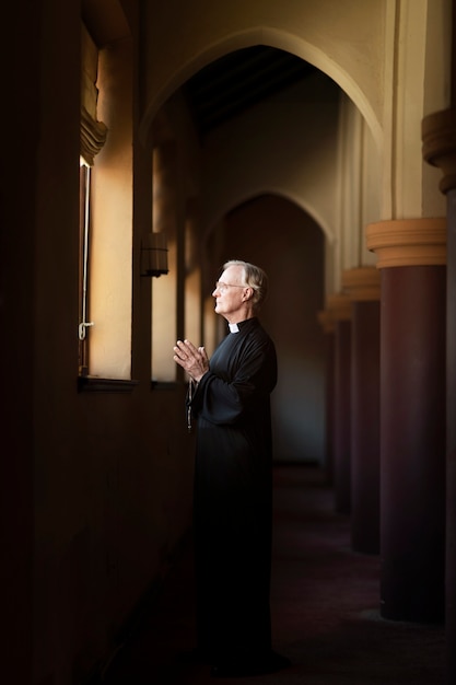 Foto sacerdote che prega in chiesa