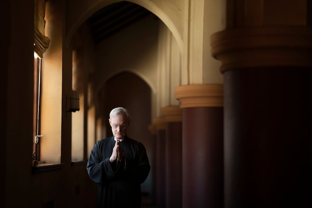 Foto sacerdote che prega in chiesa