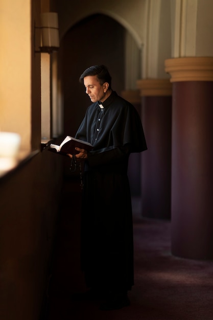 Foto sacerdote che legge dalla bibbia