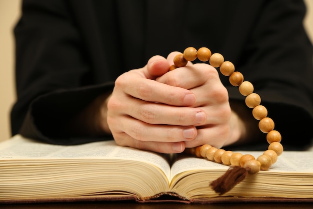 Priest reading from the holy bible close up