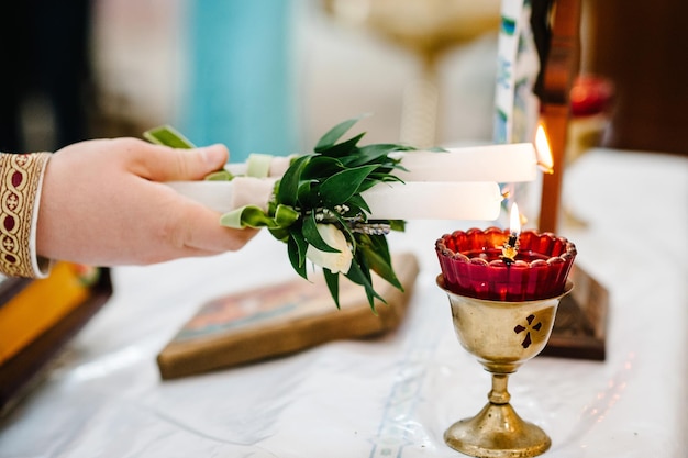 The priest's hand lights a candle in the church Frankincense is an aromatic resin used for religious rites incense and perfumes incense smoke