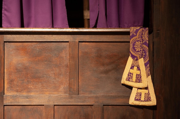 A priest's stole hangs in a confessional