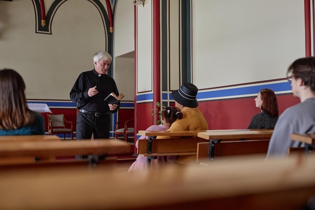 Priester die preek leest in de kerk