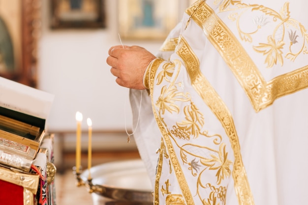 Priester steekt een kaars aan in de kerk