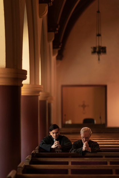 Priests praying together in church