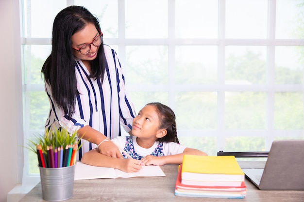 Primary school girl studying with teacher in the class