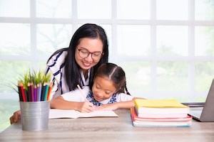 Primary school girl studying with teacher in the class