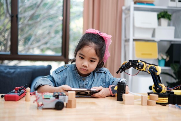 사진 stem 수업에서 자동차를 제어하기 위해 앱을 사용하는 초등학교 소녀