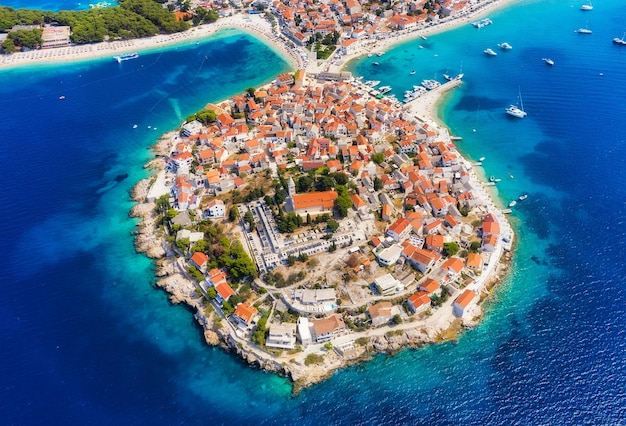 Foto città di primosten croazia vista della città dall'alto vista sul mare con spiaggia e centro storico vista dal drone sulla penisola con case paesaggio durante il tramonto viaggi e vacanze immagine