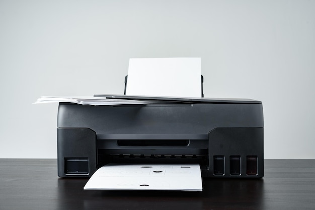 Photo printer with paper on gray background close up