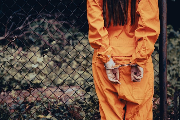 Prisoner in orange robe conceptPortrait of asian woman in Prison uniforms on white background