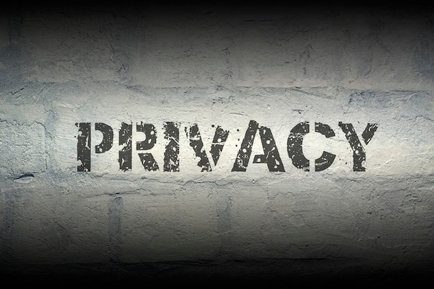 Privacy black stencil print on the grunge brick wall with gradient effect; specially designed font is used