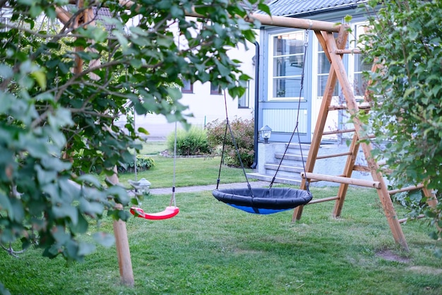 Private house backyard featuring garden trees and a swing in centre