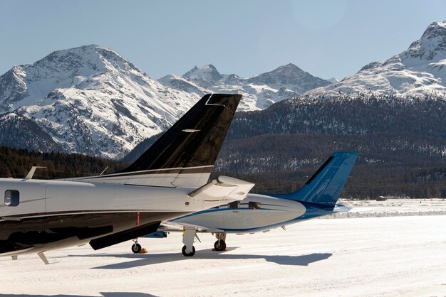 Foto jet privati e un elicottero volante all'aeroporto di engadine st moritz