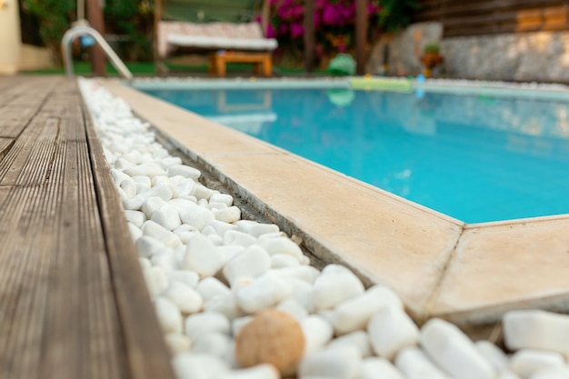 Private pool and deck next to tropical island villa.white stones, wood, close up