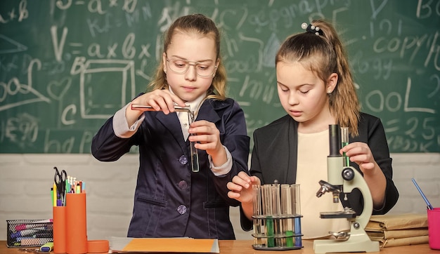 Scuola privata indagine sul progetto scolastico esperimento scolastico concetto di scienza studenti del ginnasio con uno studio approfondito delle scienze naturali uniforme scolastica femminile impegnata a dimostrare la propria ipotesi