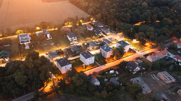 Private territory with houses and street lit at night, view of\
private houses from above