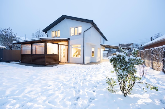 Private white house in winter at sunset