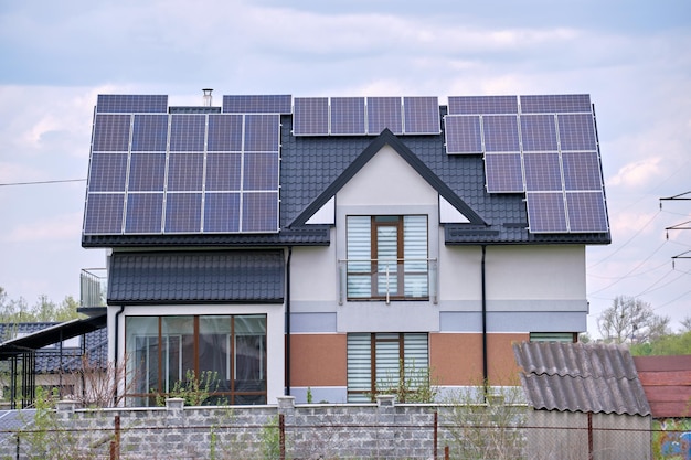 Privé huisdak bedekt met fotovoltaïsche zonnepanelen voor het opwekken van schone ecologische elektrische energie in een landelijk stadsgebied in de buitenwijken Concept van autonoom huis