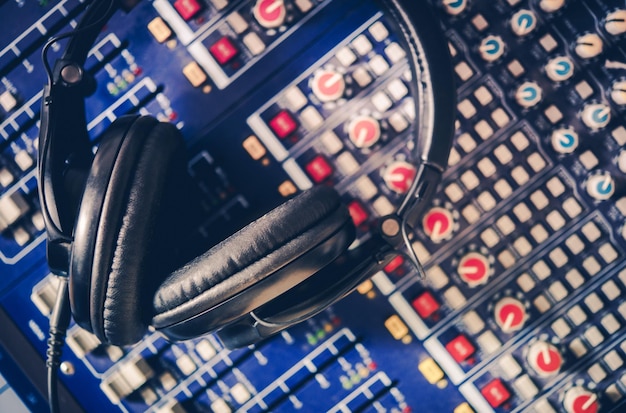 Photo pro headphones on the sound mixing table audio mixer recording studio and audio broadcast theme