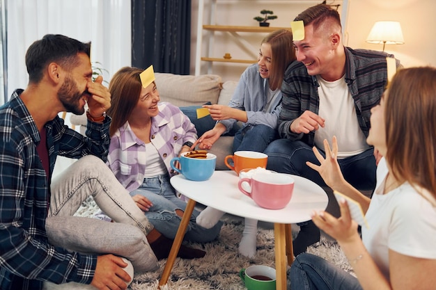 Proberen te raden wie ik ben Vriendengroep viert samen binnen feestje