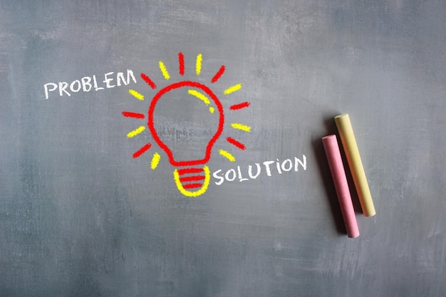 Problem solving idea chalkboard drawing image of lightbulb with\
text problem and solution