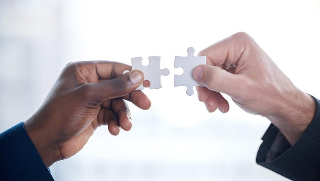 problems are better solved together cropped shot of two unrecognizable businesspeople completing a puzzle together in a modern office