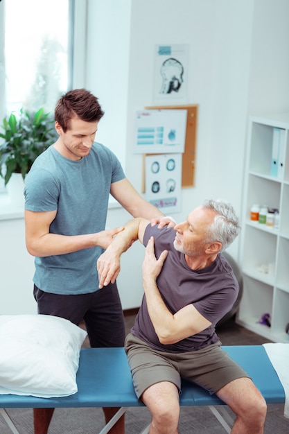 Problems with hand. Top view of a nice aged male patient while having problems with his hand