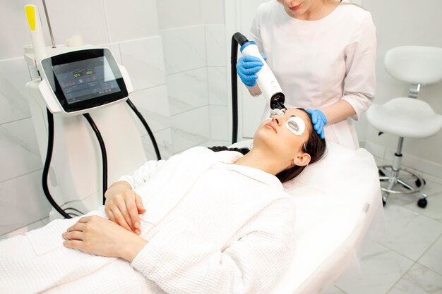 Procedure of laser stimulation of hair growth doctor cosmetologist makes procedure against hair loss