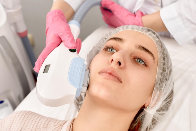 Procedure of photoepilation in the beauty salon Young Woman Receiving Epilation Laser Treatment On Face At Beauty Center Close Up