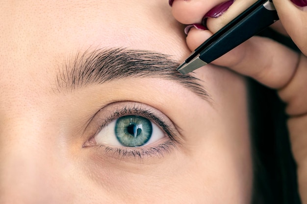 Procedure for plucking eyebrows in a beauty salon closeupMakeup Eyebrow Makeup Eyes