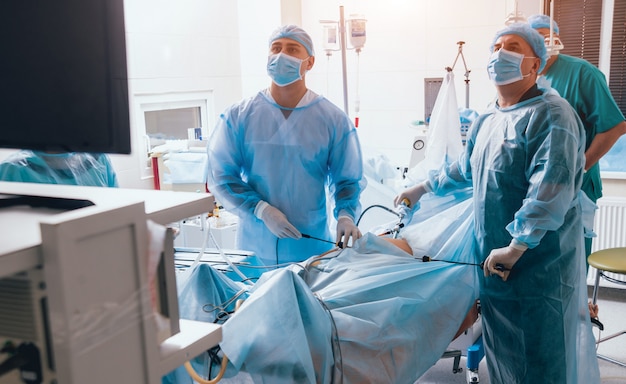 Proces van gynaecologische chirurgie met laparoscopische apparatuur. Groep van chirurgen in operatiekamer met chirurgische apparatuur