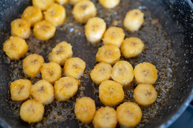 Proces van het koken van gekarameliseerde banaan in een koekenpan thuis selectieve focus gezond