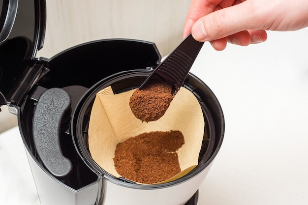 Proces van het maken van koffie van gemalen bonen in een koffiezetapparaat - koffie in een papieren filter laden