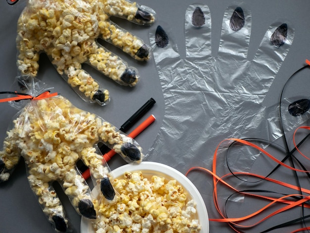Foto proces van het maken van leuke verpakkingen voor popcorn in de vorm van een hand met klauwen voorbereiding van halloween edibl