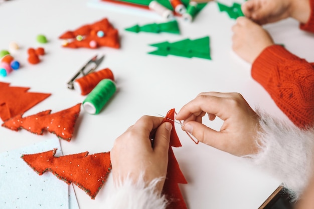 Proces van het met de hand maken van zacht speelgoed met vilt en naald voor de versiering van de kerstboom