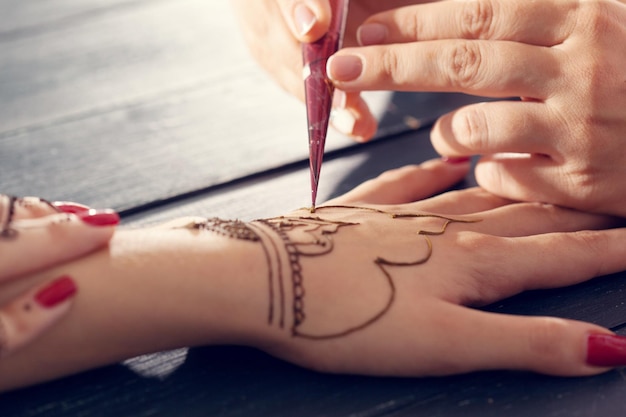 Processo di applicazione di mehndi su mani femminili