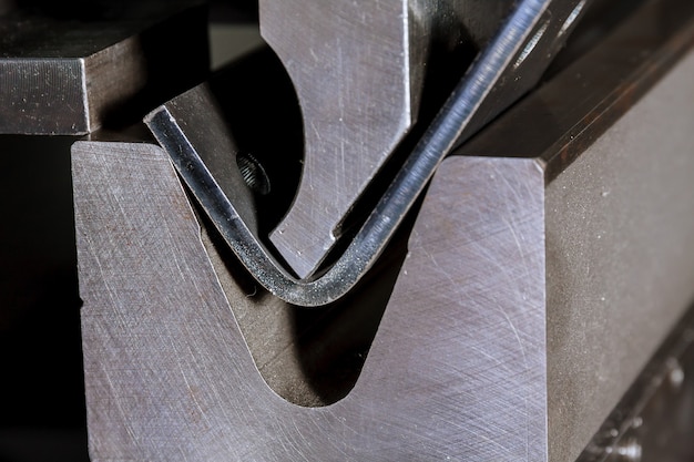 The process of bending sheet metal on a hydraulic bending machine. Metalworking plant.