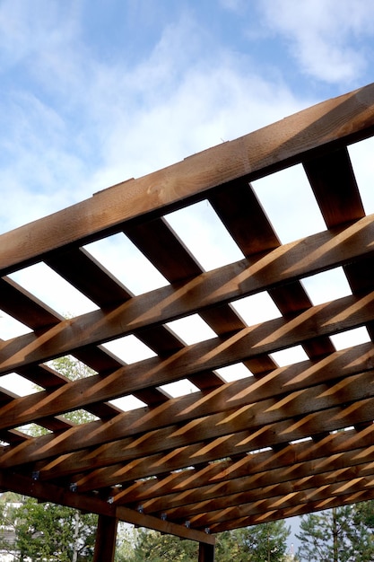 Process of building a wooden canopy from brown boards with crate in the rural place in summer day